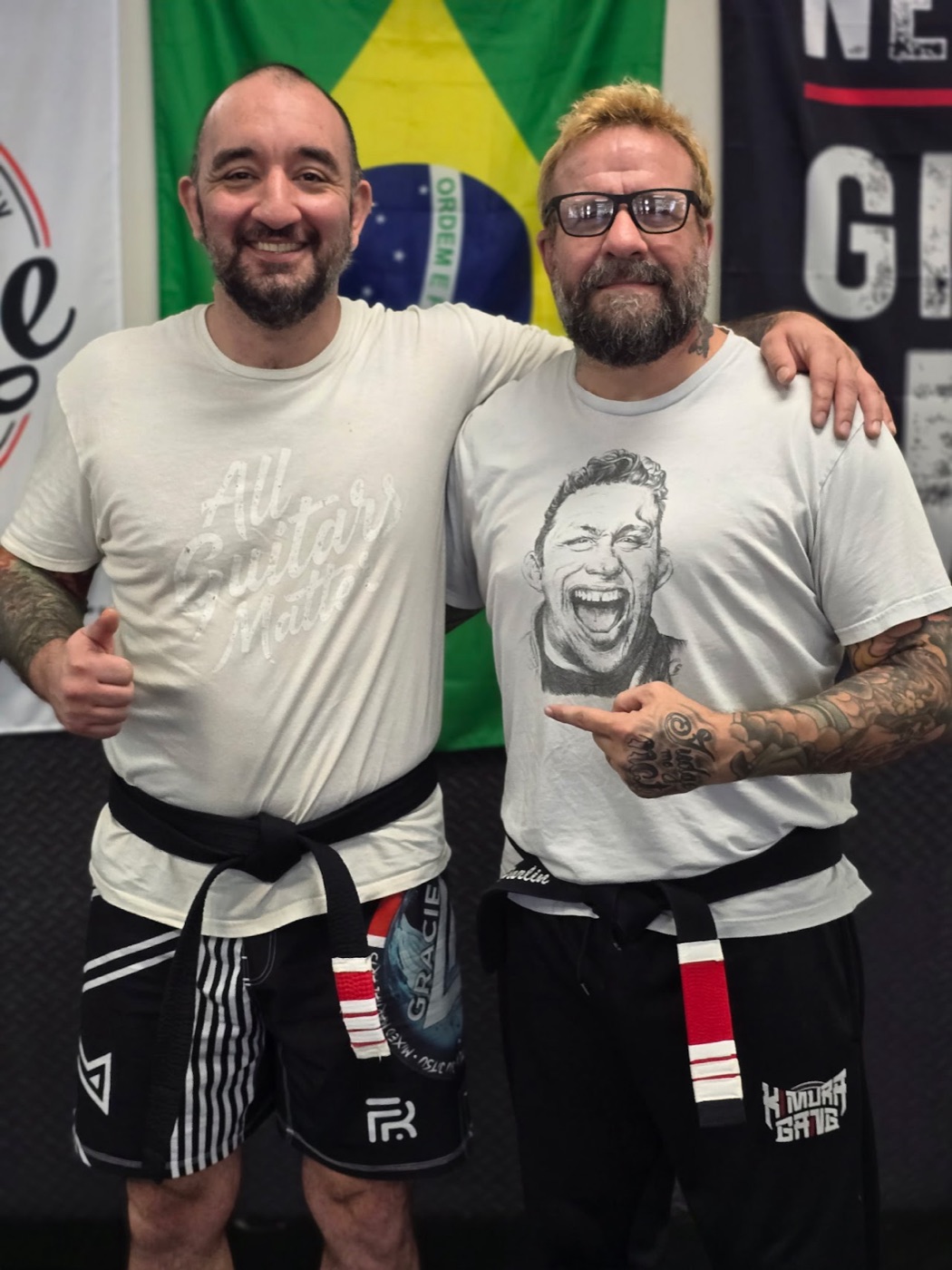 Sonny Parlin with his professor, Robby Donofrio, in front of a Brazilian flag