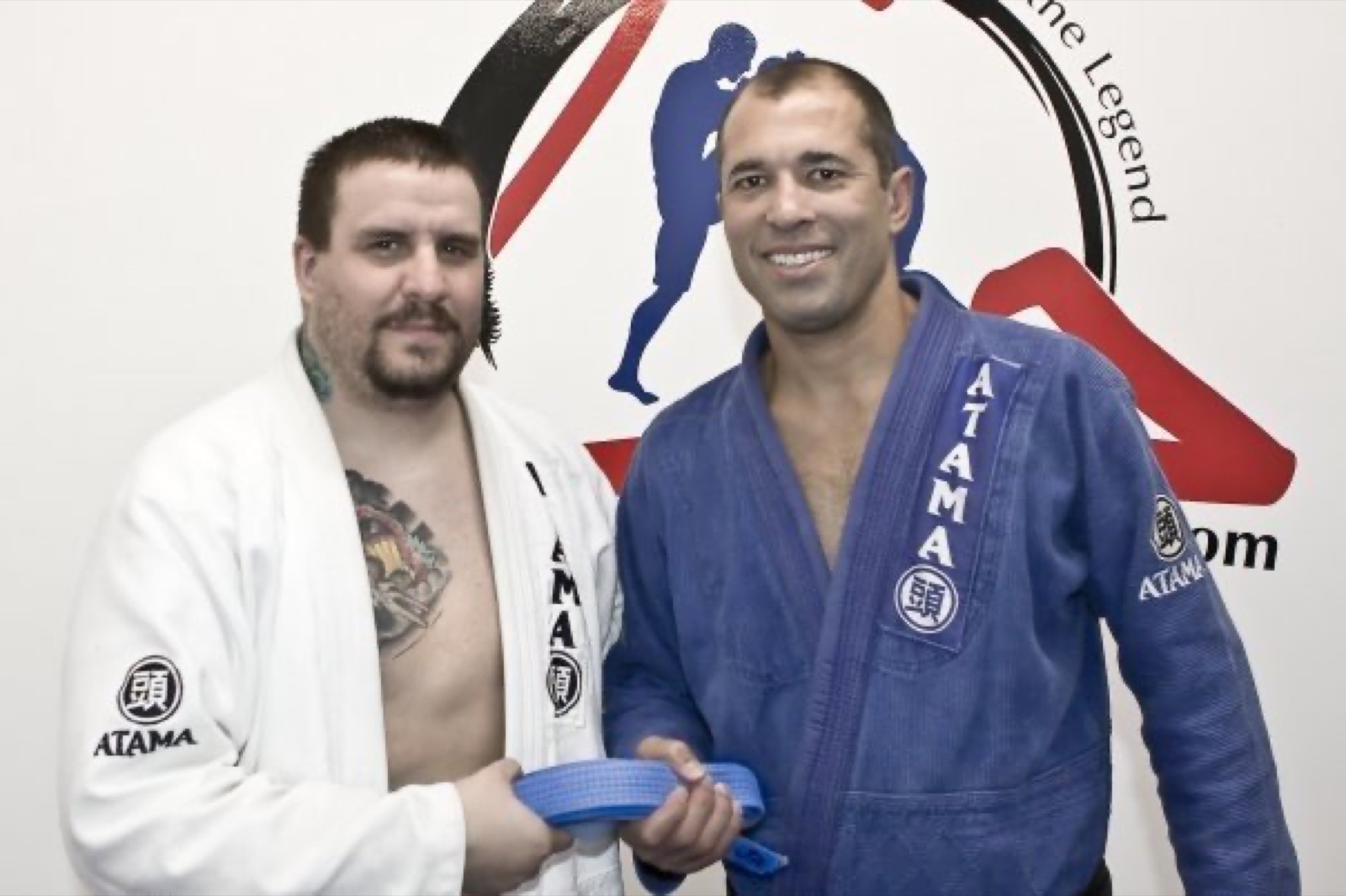 A young Sonny Parlin in a white gi receiving his blue belt from Royce Gracie