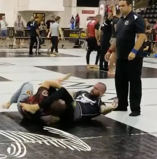 Sonny Parlin in a black rashguard attacking a leg entanglement in a no-gi match